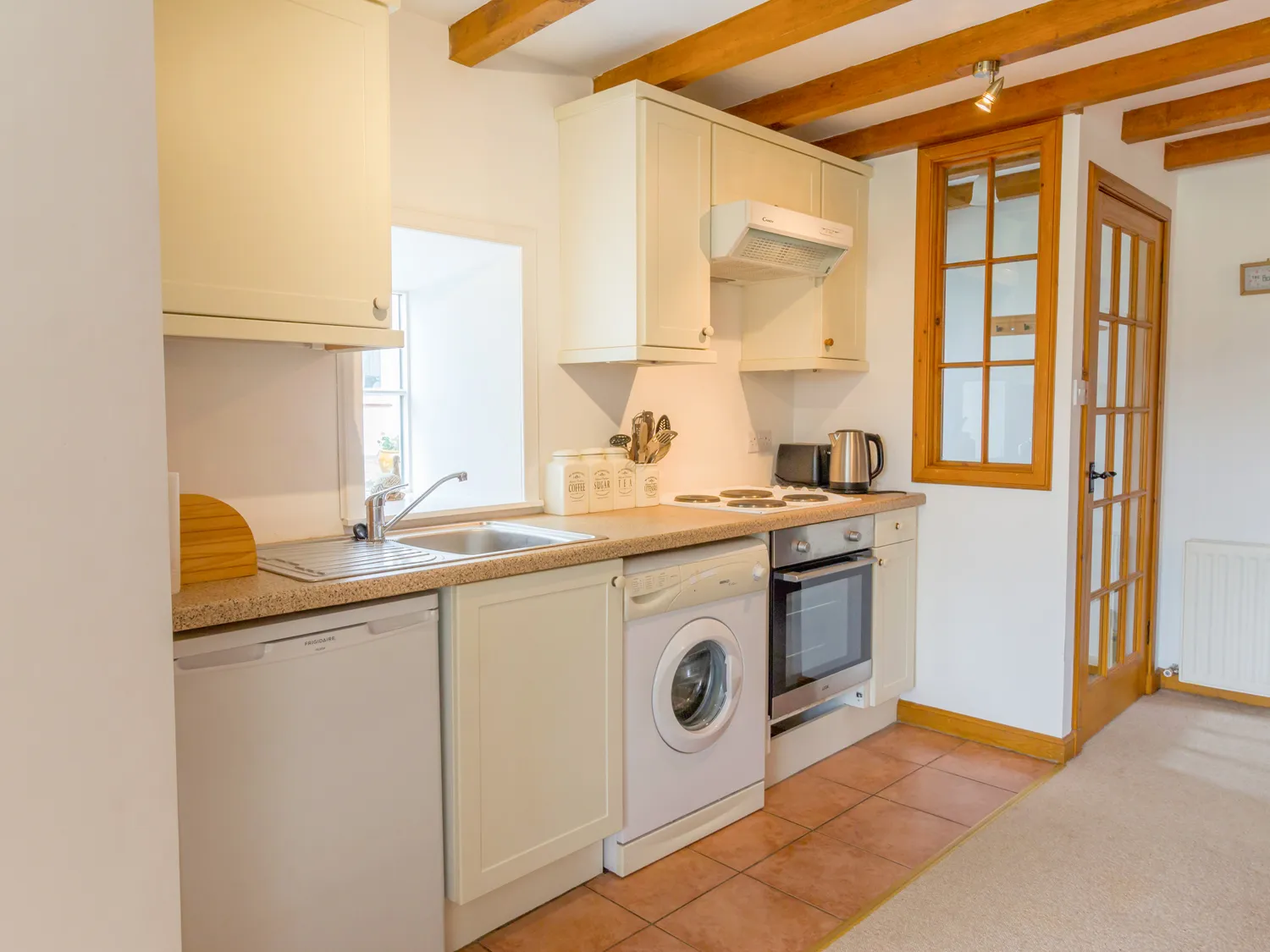 A fully-equipped kitchen at The Bothy featuring modern appliances and a country-style design.